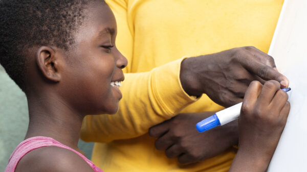 close-up-smiley-kid-writing-board
